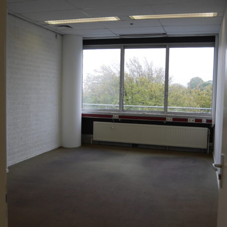 Een kantoorkamer op het noorden, met antraciet vloerbedekking, verwarming, systeemplafond met verlichtingsarmatuur